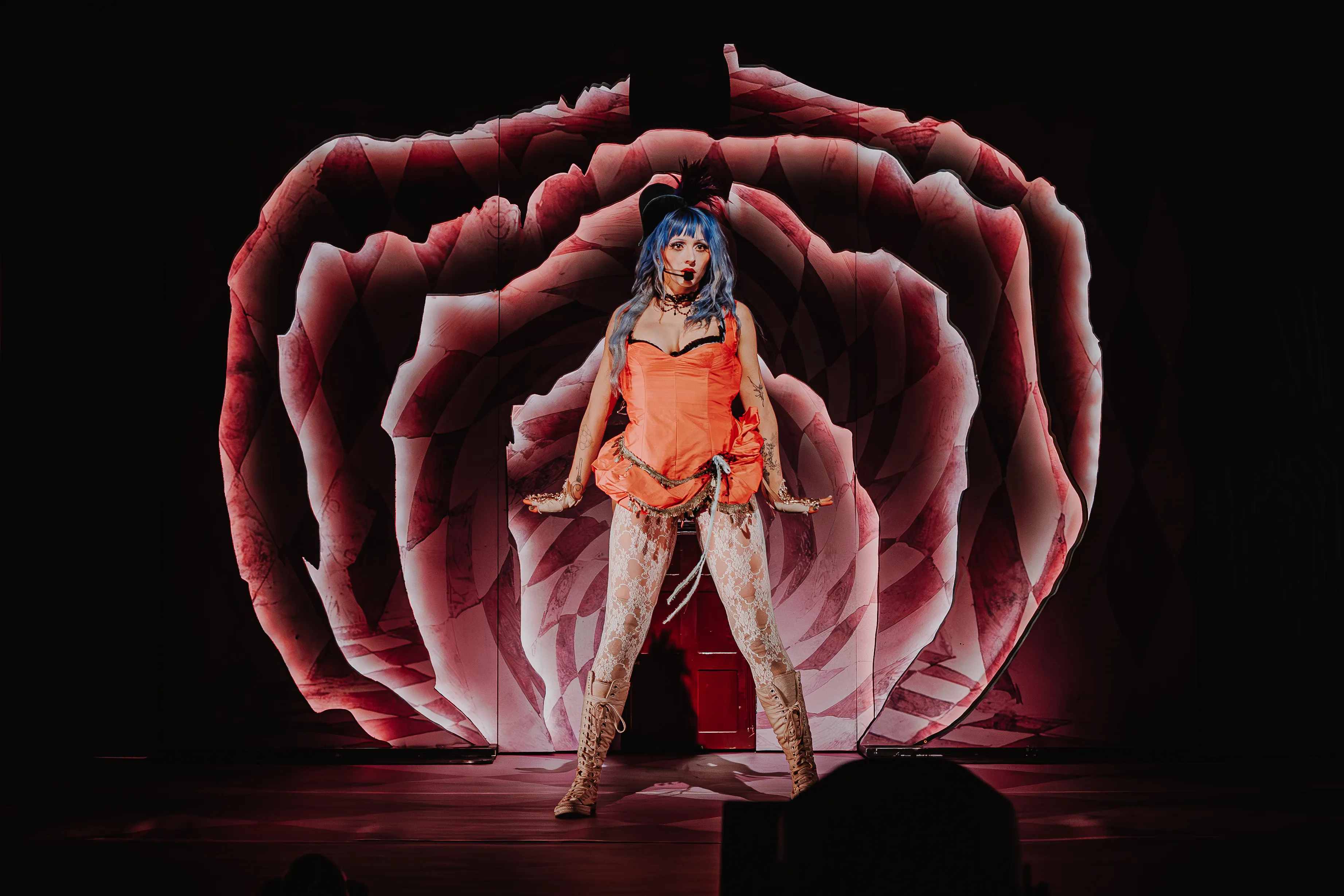 Ashnikko, live on stage against a pink patterned set