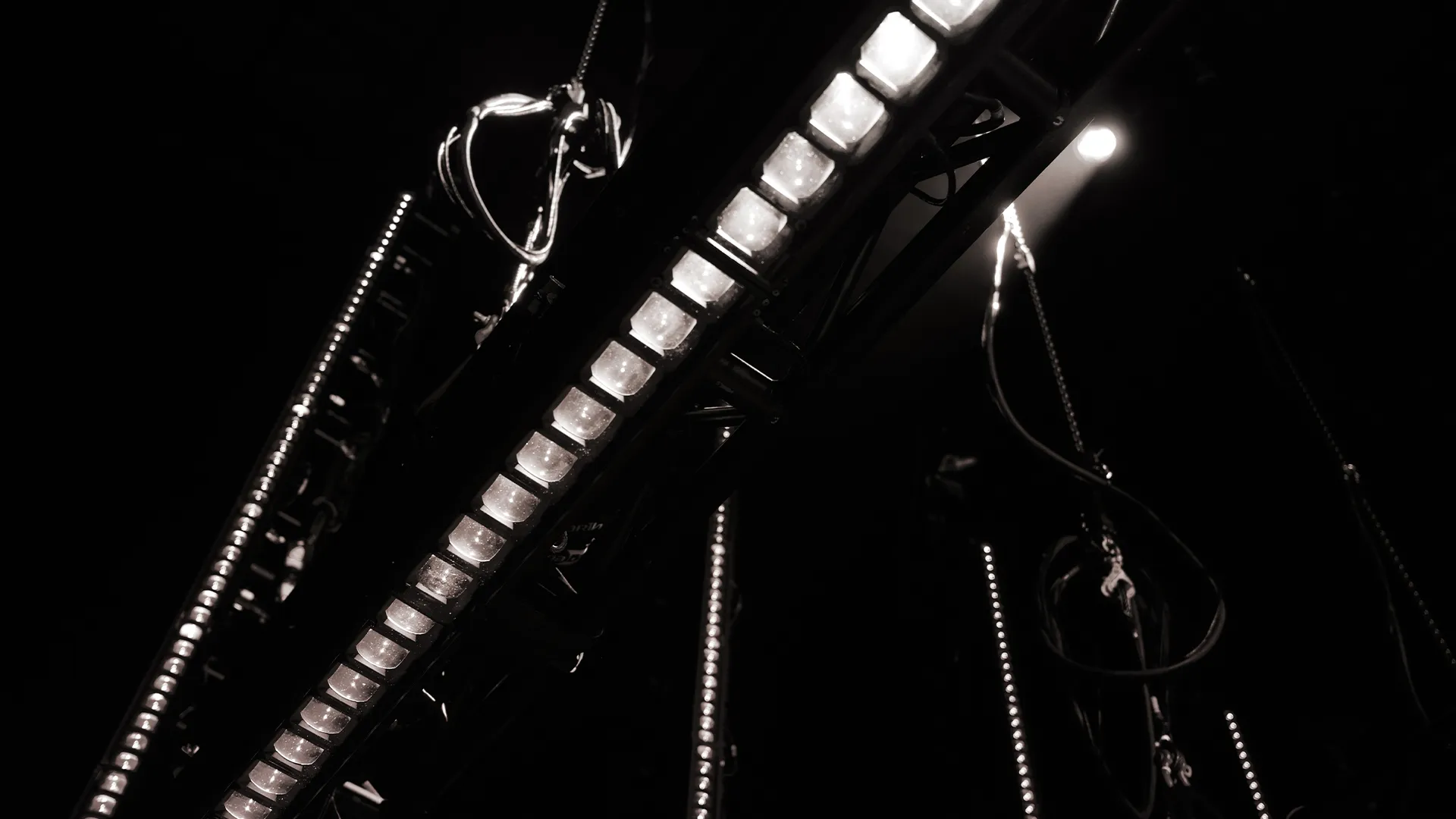 LED battens rigged on truss, shot in black and white.