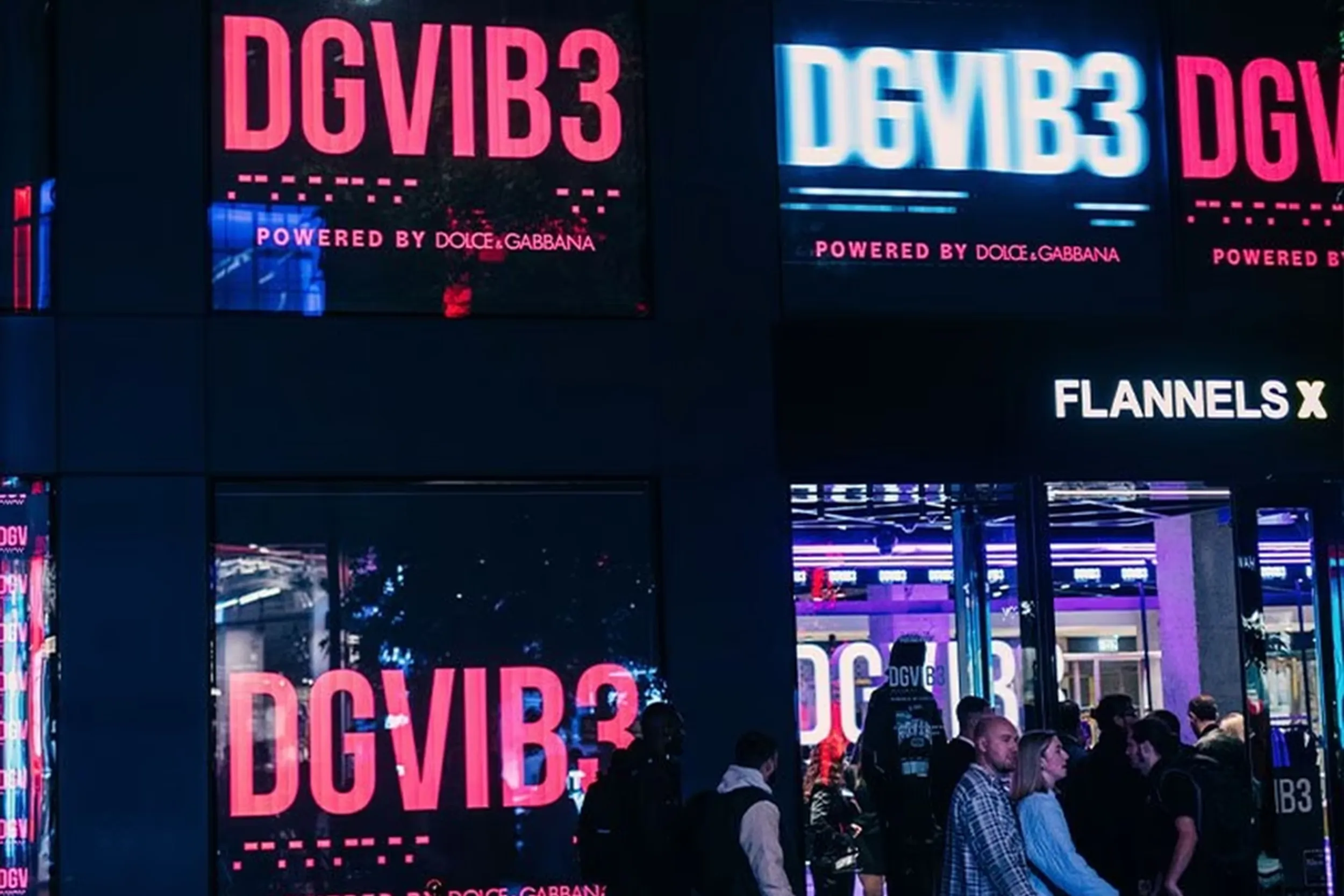 Crowds queueing outside a store lit with red and white DGVIB3 screens