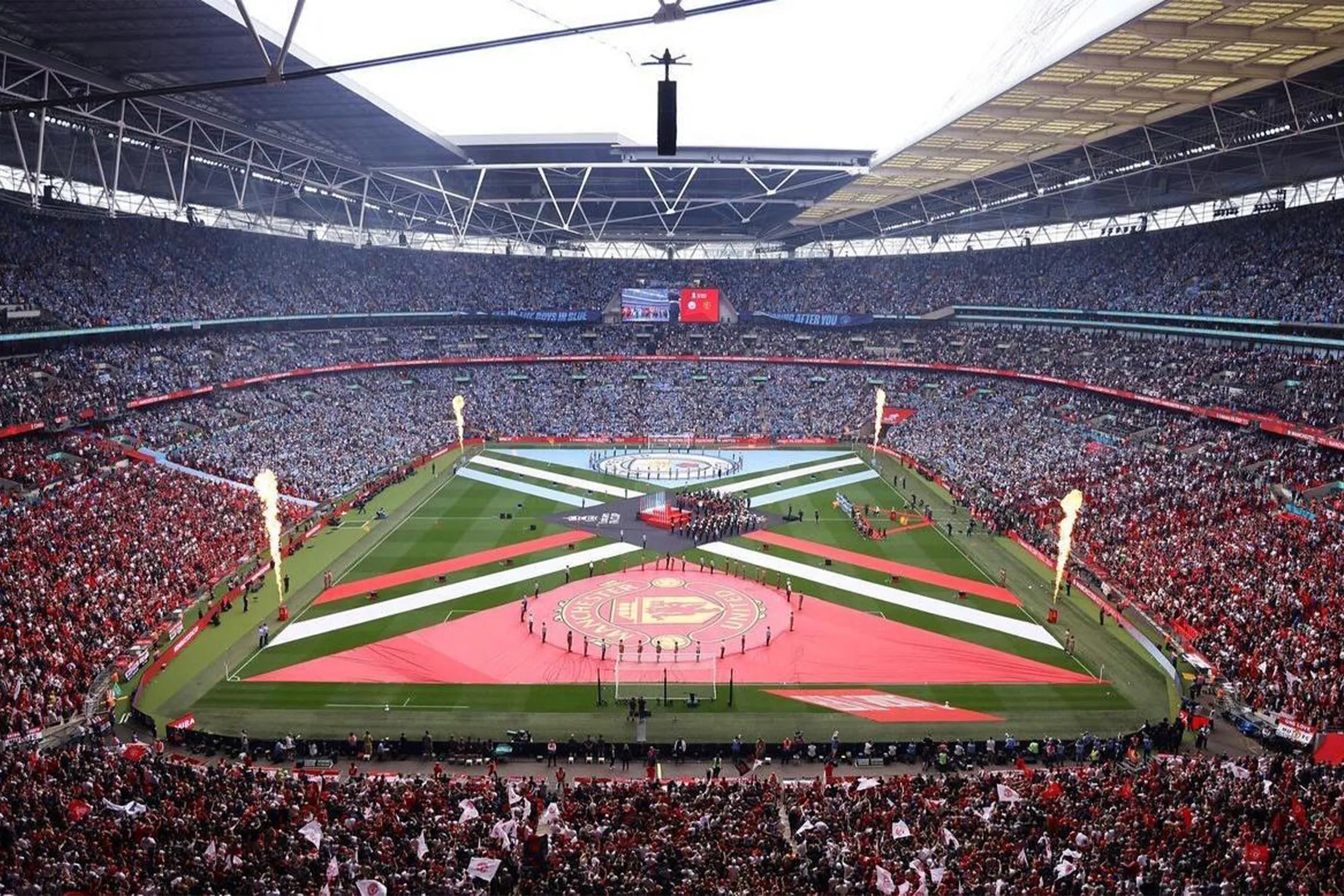 The whole stadium packed for the pre-match show, flames rising at the corners of the pitch display