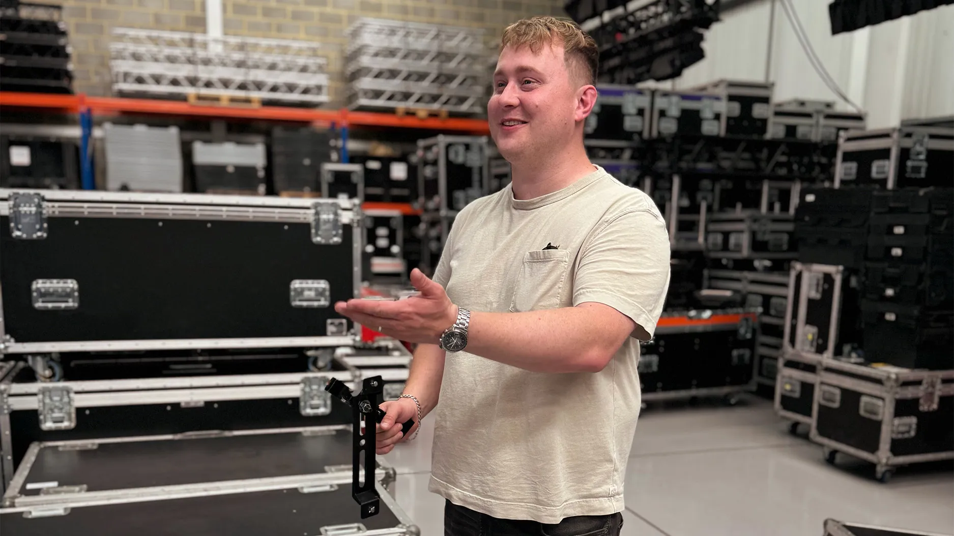 James in the warehouse, holding a lighting fixture bracket