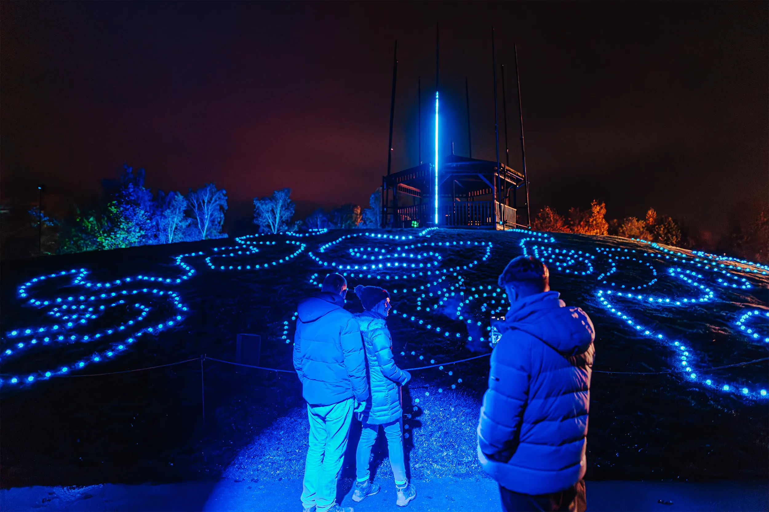 A visitor plays the interactive drums, lighting the forest around them