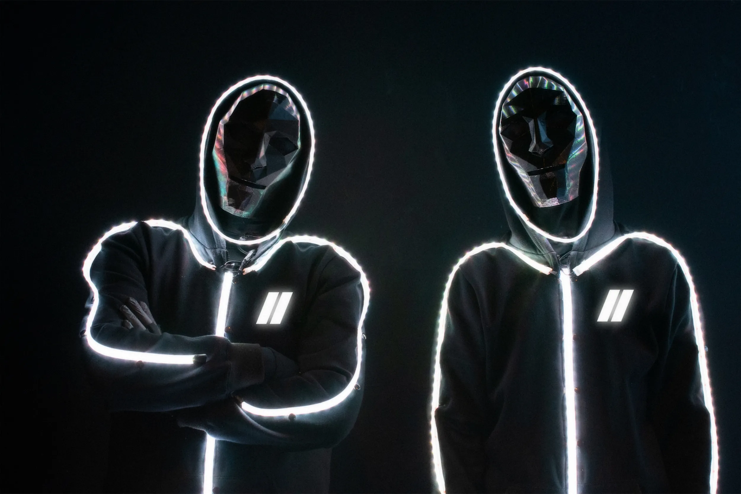 Close-up of two stickmen in black hoodies traced with white LED outlines, faces hidden behind mirrored masks