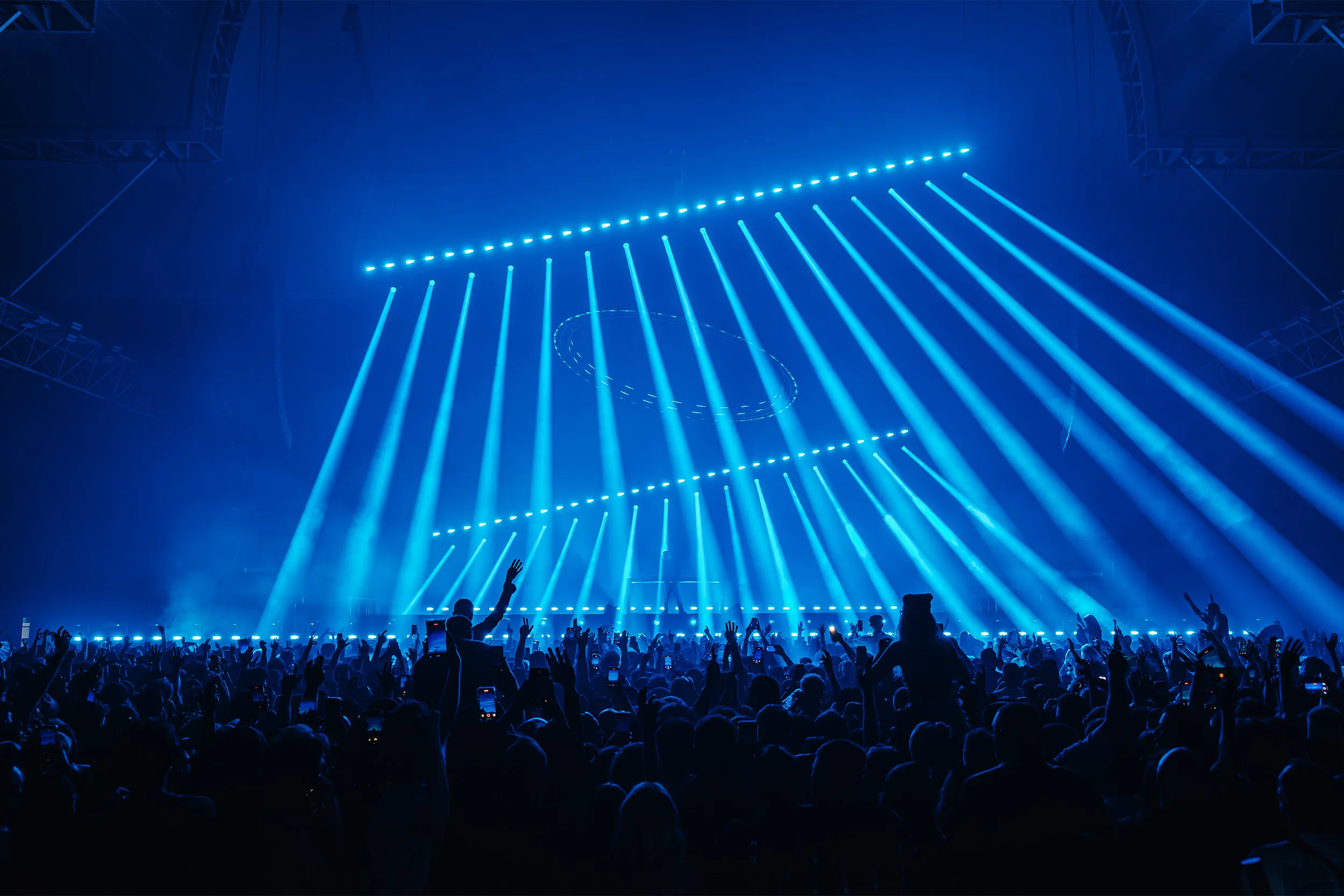 Two angled rows of blue beams raking down over the crowd