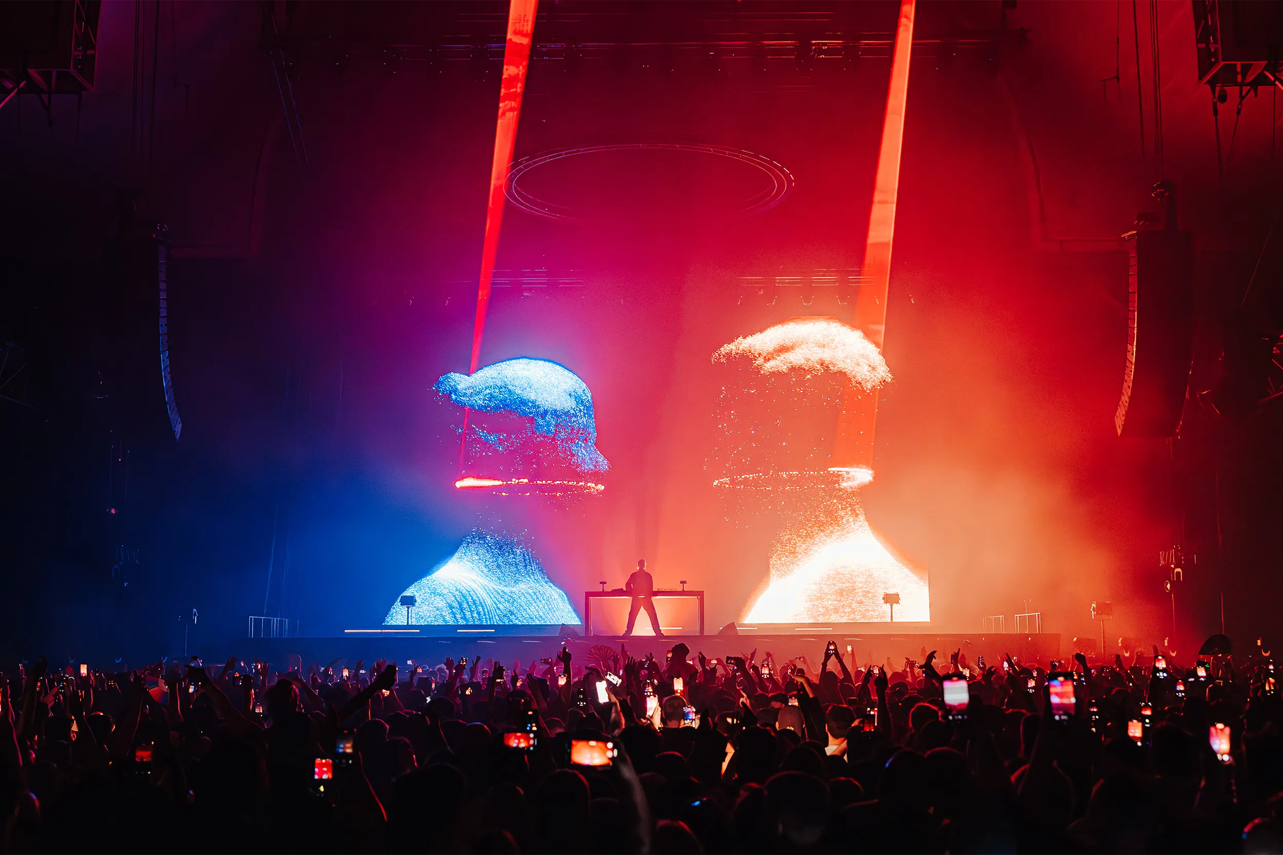 Two giant projected heads either side of the booth, one blue and one red, with red beams above